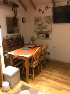 a dining room with a table and chairs and a television at Lovely cottage in Lower Bracky