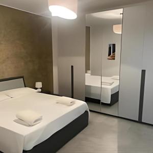 una camera da letto con un grande letto bianco e uno specchio di La Maison di Aurora a Orbassano
