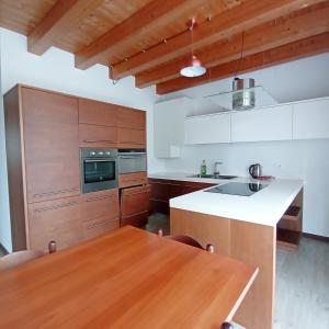 cocina con armarios de madera y mesa de madera en Agriturismo Trabucco en Casale sul Sile