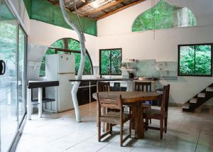 - une cuisine avec une table en bois et quelques fenêtres dans l'établissement Casa Sarah, à Nosara