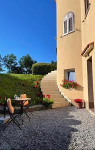 a table and chairs in front of a building with stairs at Studio apartment Lu in Rupa