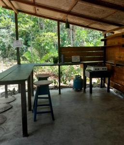 una mesa de picnic y un taburete en un pabellón en Quarto na floresta com saída no igarapé - Espaço Caminho das pedras en Alter do Chao