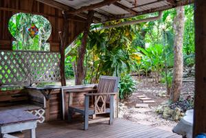 een houten pergola met een tafel en een stoel op een terras bij Casa Sarah in Nosara