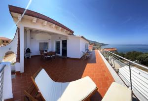 un balcón de una casa con vistas al océano en TITINO stupendo appartamento in villa fronte Mare - Golfo dell'Asinara - Internet Free, en Codaruina