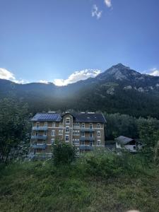 un bâtiment sur une colline avec des montagnes en arrière-plan dans l'établissement Zum Radwerk TOP 11, à Vordernberg