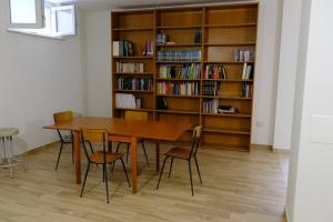 una mesa y sillas en una habitación con estantería. en Casa Celeste, en Nocera Umbra