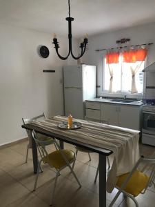 a kitchen with a table with chairs and a chandelier at Complejo Los Aromitos 1 in Río Ceballos