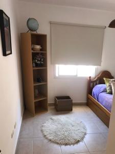 1 dormitorio con cama y alfombra blanca en Complejo Los Aromitos 1 en Río Ceballos