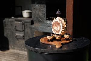 una mesa con un reloj y tazas en ella en Casa cu Salcâmi, en Moieciu de Jos
