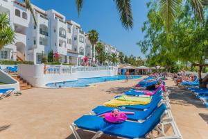 a row of beach chairs at the pool at the resort at Aparthotel Holiday Center in Santa Ponsa