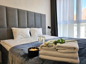 a bedroom with a bed with towels and wine glasses at URBAN APARTMENTS PREMIUM, Opolska 10 No 77B, Free Garage, Self Check-in in Katowice