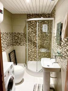 a bathroom with a shower and a toilet and a sink at Bow Inn in London