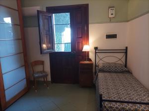 a bedroom with a bed and a door and a chair at Aimola in Avola