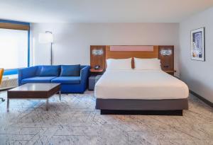 a hotel room with a bed and a blue couch at Holiday Inn Express La Mesa Near SDSU, an IHG Hotel in La Mesa