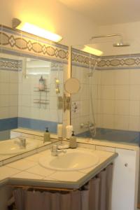 un bagno con lavandino e specchio di Bungalow La Papaye Bleue Résidence accès Piscine & Plage a Saint-François