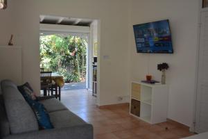 un soggiorno con un divano e un tavolo di Bungalow La Papaye Bleue Résidence accès Piscine & Plage a Saint-François