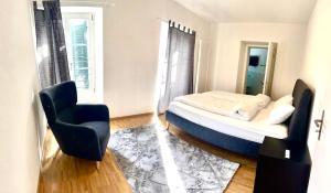 a bedroom with a bed and a chair in it at Interlaken Best View Deluxe Apartment in Interlaken