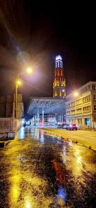 una ciudad por la noche con un edificio con una torre de reloj en La Floquettoise maison cocooning proche gare et centre-ville, en Amiens