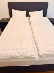 two beds with white sheets and pillows at Interlaken Best View Deluxe Apartment in Interlaken