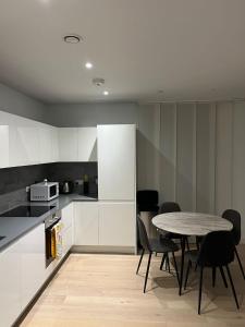 a kitchen with a table and chairs in a room at Canary Wharf Luxury 2 Bed Apartment in London