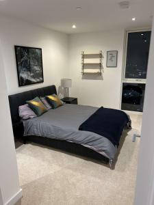 a bedroom with a bed and a window at Canary Wharf Luxury 2 Bed Apartment in London
