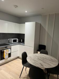 a kitchen with a table and chairs in a room at Canary Wharf Luxury 2 Bed Apartment in London