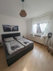 1 dormitorio con 1 cama, 1 silla y ventanas en Ferienwohnung Mila, Scheidt en Saarbrücken