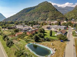 una vista aerea di una piccola città con montagne sullo sfondo di Casa Oliver, tra la Calanca e i castelli di Bellinzona a Grono