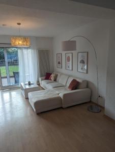 a living room with a white couch and a table at Ferienwohnung Mila, Scheidt in Saarbrücken