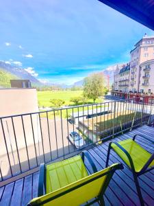 a balcony with two chairs and a view of a street at Interlaken Best View Deluxe Apartment in Interlaken