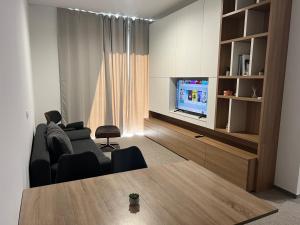 a living room with a couch and a television at Diamant apartment pri sejmu MOS in Celje