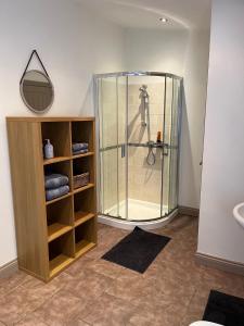 ein Bad mit einer Dusche, einem Waschbecken und einem Spiegel in der Unterkunft APARTMENT 185 in Blackwood