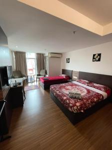 a hotel room with a bed and a couch at Nazrins Studio Apartment KBCP in Kota Bharu