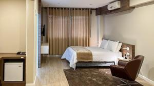 1 dormitorio con cama, escritorio y silla en Tri Hotel Lajeado, en Lajeado