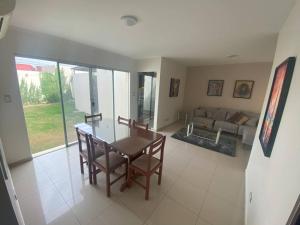 uma sala de estar com uma mesa e um sofá em Hermosa casa en cond. privado em Santa Cruz de la Sierra