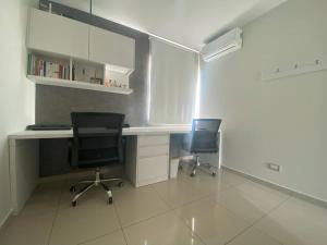 an office with two chairs and a desk and a computer at Hermosa casa en cond. privado in Santa Cruz de la Sierra +17 photos
