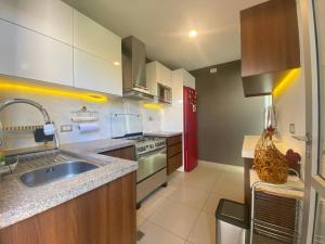 a kitchen with a sink and a red refrigerator at Hermosa casa en cond. privado in Santa Cruz de la Sierra