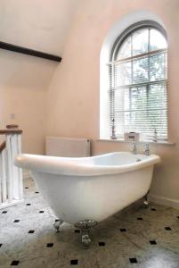 baño con bañera blanca y ventana en Folly - Middleton Hall Estate en Belford