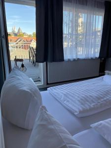 ゴスラーにあるTrattoria & Apartments - Casa da Enzoの窓付きの客室で、白いベッド2台が備わります。