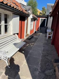 a white bench sitting outside of a building at Historisk Charm i Hjärtat av Gamla Stan Kalmar in Kalmar