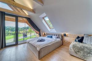 a bedroom with a bed and a large window at Pine Tree Chalet in Zawoja