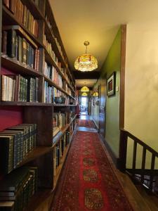 un pasillo con estanterías y una alfombra roja en una biblioteca en Le Presbytere, en Castex
