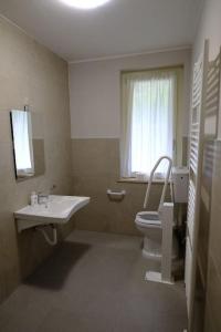baño con lavabo y aseo y ventana en Casa Celeste, en Nocera Umbra