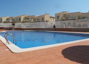 a swimming pool with blue water in a yard at BUNGALOW 145 MONTE Y MAR SERENA in Gran Alacant