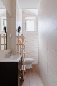 a bathroom with a sink and a toilet and a mirror at Casa do Azulejo II in Setúbal