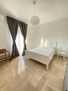 a white bedroom with a bed and a table at Casa Frida in Bitonto