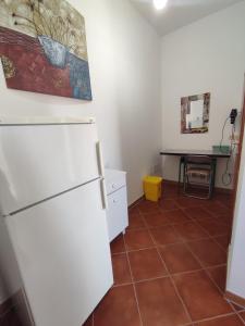 a kitchen with a white refrigerator and a table at B&B Villa Nicoletta in Peschici
