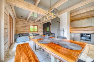 a kitchen and dining room with a large wooden table at Pine Tree Chalet in Zawoja