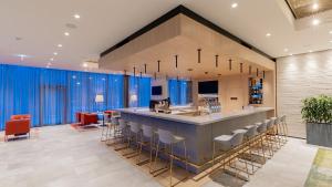 a large kitchen with a bar with stools at Hilton Garden Inn Wiener Neustadt in Wiener Neustadt