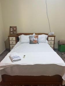 a bedroom with a large bed with white sheets at CASA DE PRAIA CAJUEIRO ALTER in Alter do Chao